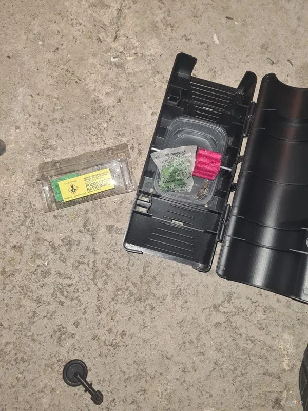 Odprta vabna postaja in označena kontrolna vaba na betonu.