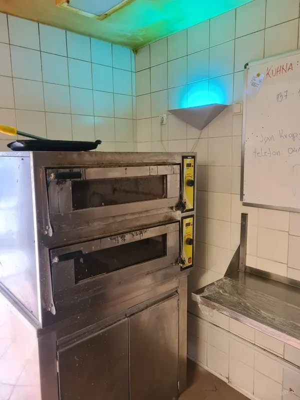 UV lovilec insektov, nameščen nad opremo v profesionalni kuhinji.
